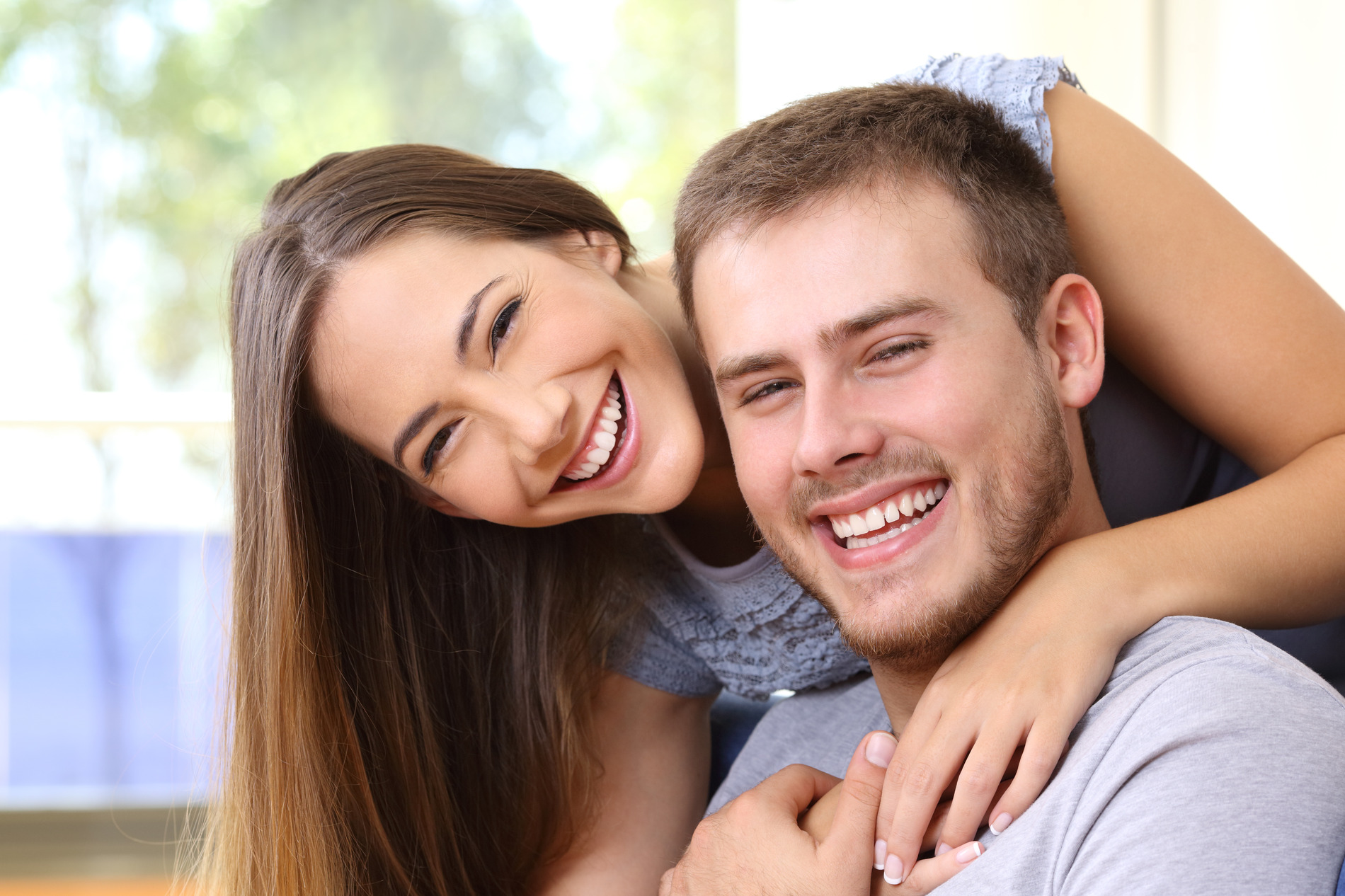 Couple smiling and embracing after oral surgery in Seminole, FL